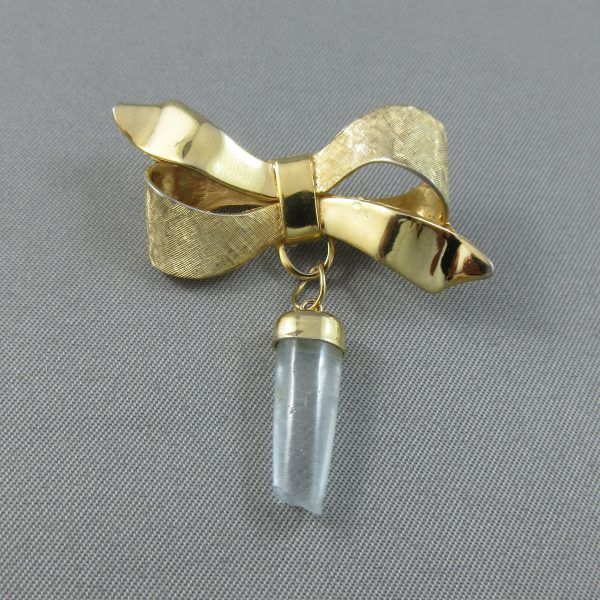 Ribbon brooch with a light blue stone